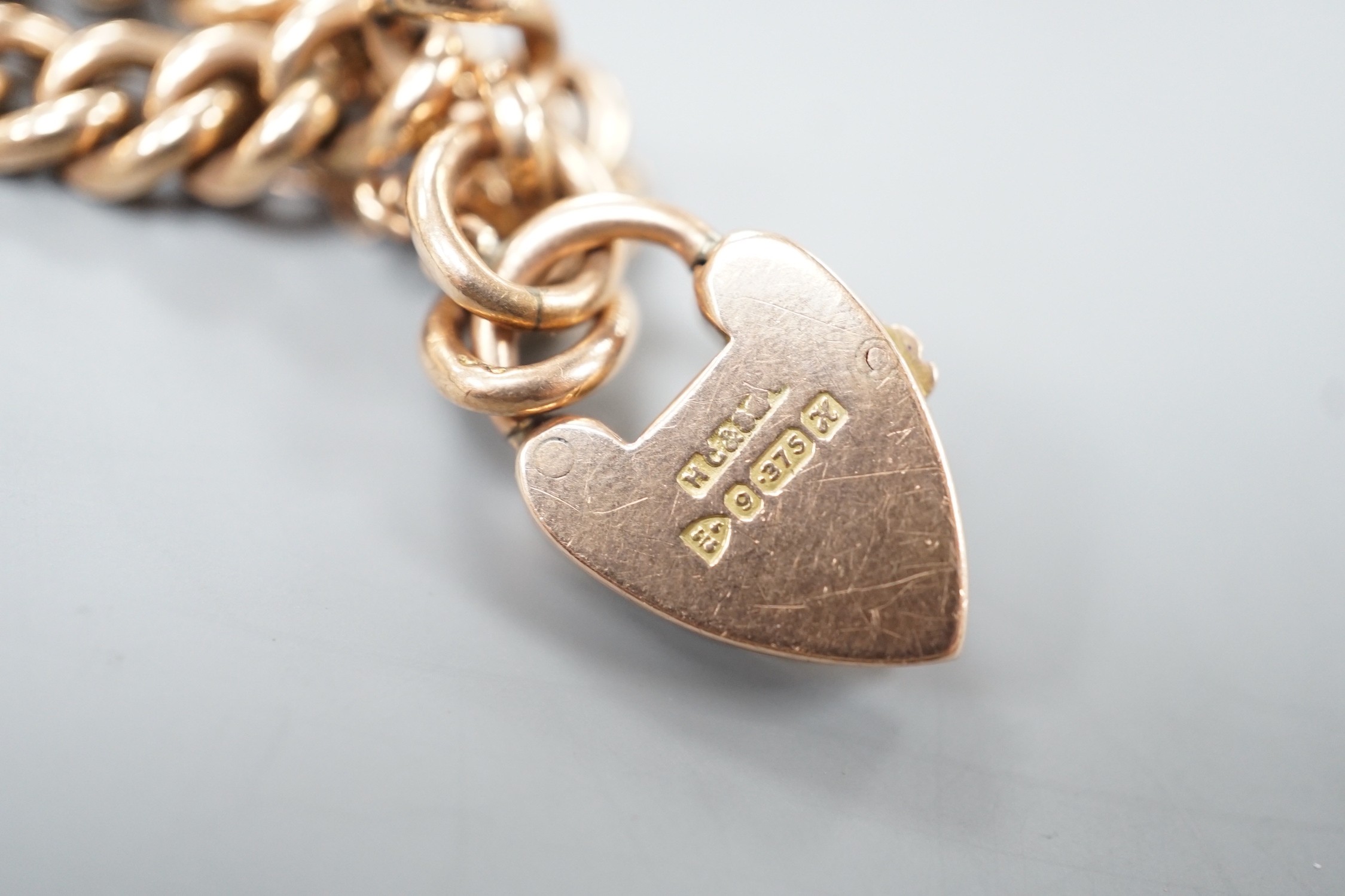 An Edwardian 9ct gold curblink bracelet, with heart shaped padlock clasp, 19cm, 11.3 grams.